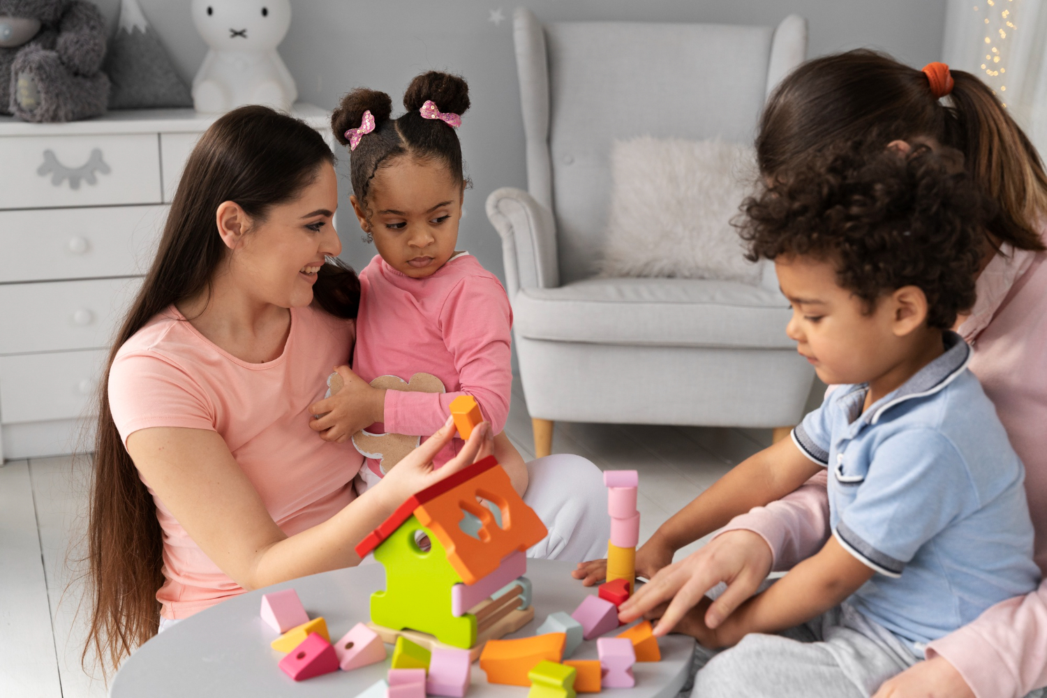 Therapist working with a child on speech therapy while another engages in occupational therapy at Theracare.